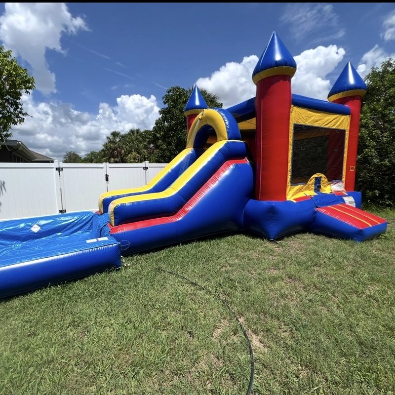 Blue, red and yellow castle combo with a slide and landing pool